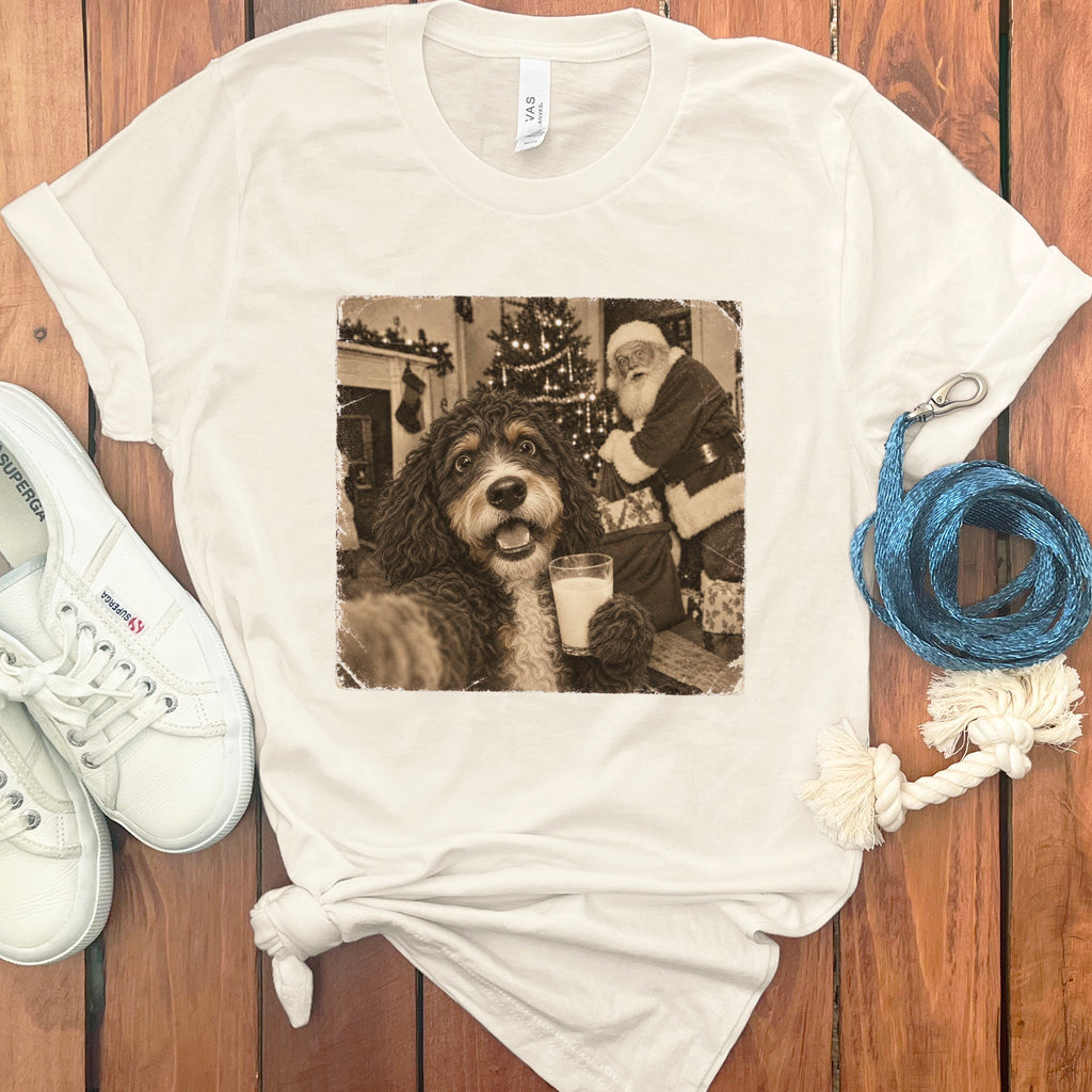 Cream t-shirt featuring a vintage sepia graphic of a dog holding a glass of milk with Santa Claus in the background.
