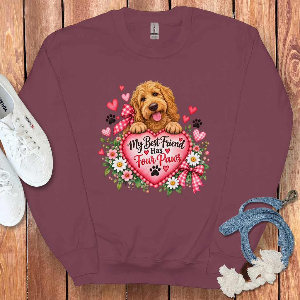 Maroon crewneck sweatshirt featuring a graphic of a golden puppy resting on a pink heart with text reading My Best Friend Has Four Paws surrounded by flowers and paw prints.
