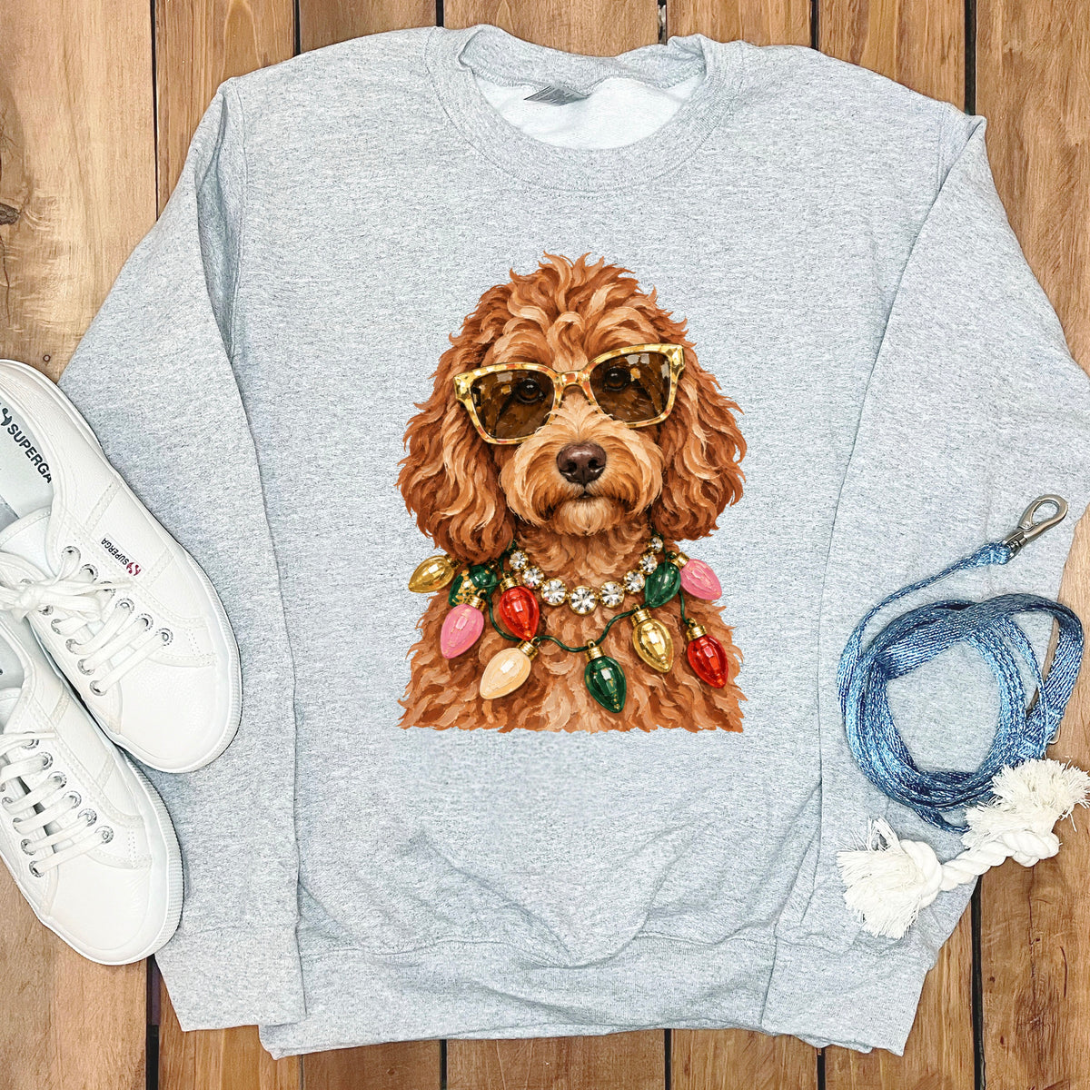 Light gray sweatshirt with illustration of a dog wearing sunglasses and Christmas lights.