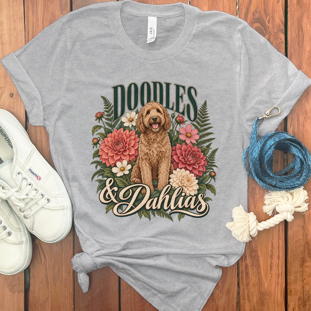 Grey t-shirt with "DOODLES & Dahlias" text and a doodle dog among flowers.