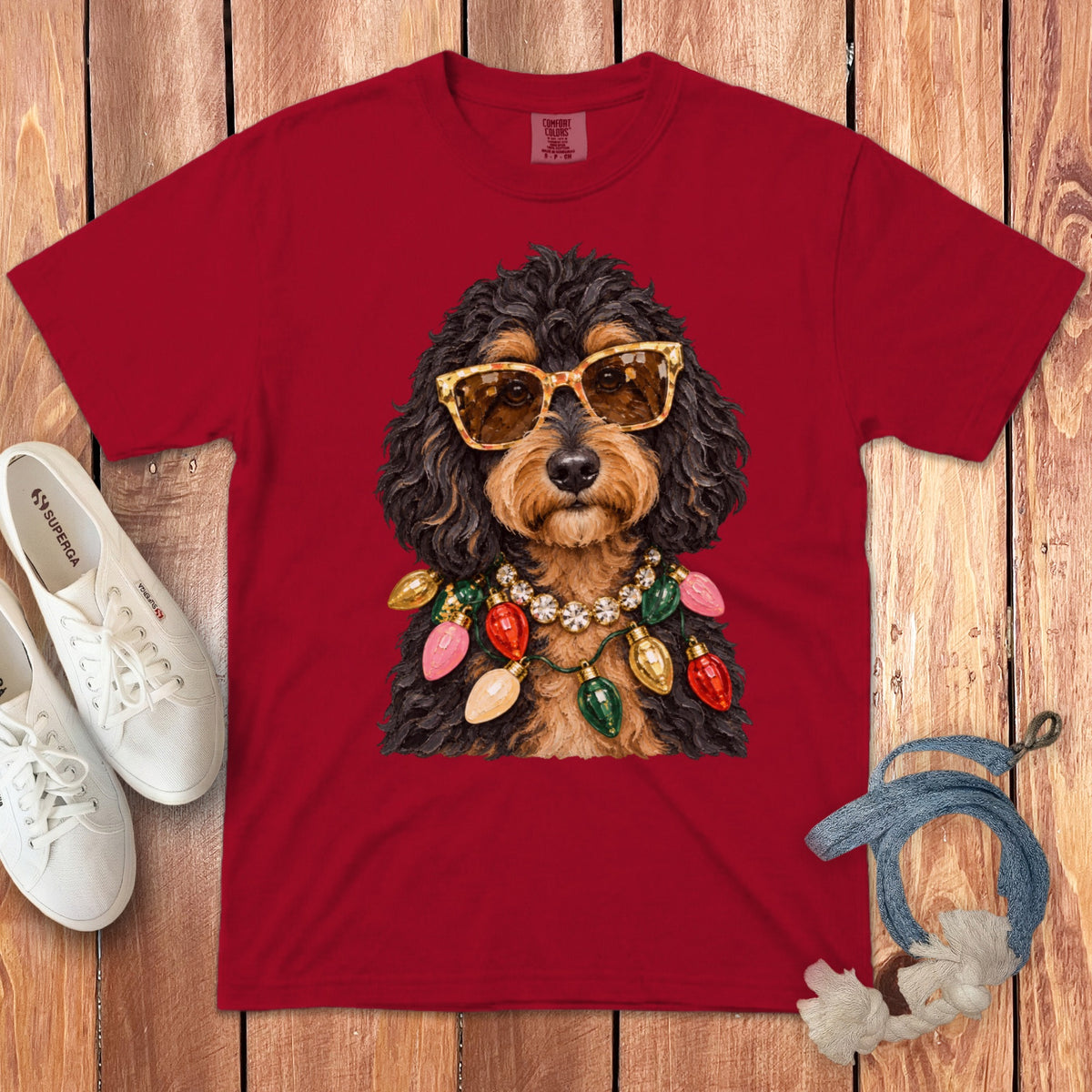 Red t-shirt with a dog wearing sunglasses and Christmas lights necklace graphic.