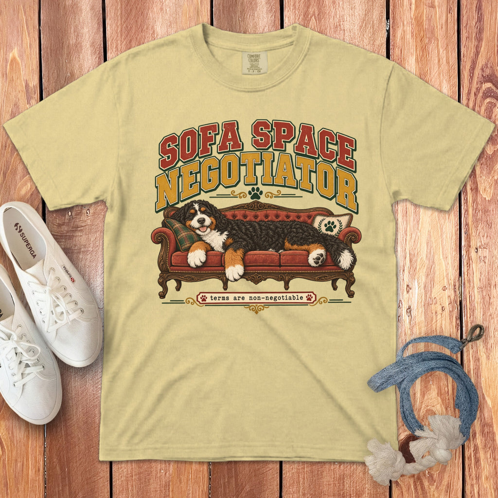 Light yellow t-shirt featuring a graphic of a Bernese Mountain Dog lying on a red couch, with text that reads Sofa Space Negotiator.