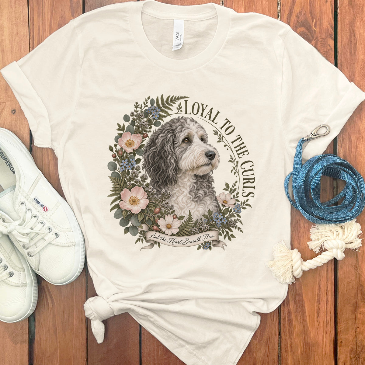 Cream t-shirt with a portrait of a dog surrounded by flowers and text.