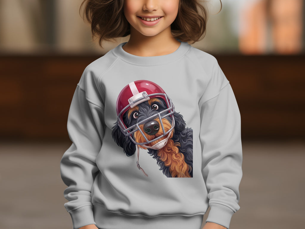 A dog wearing a red and white football helmet peeks from the chest of a grey sweatshirt.
