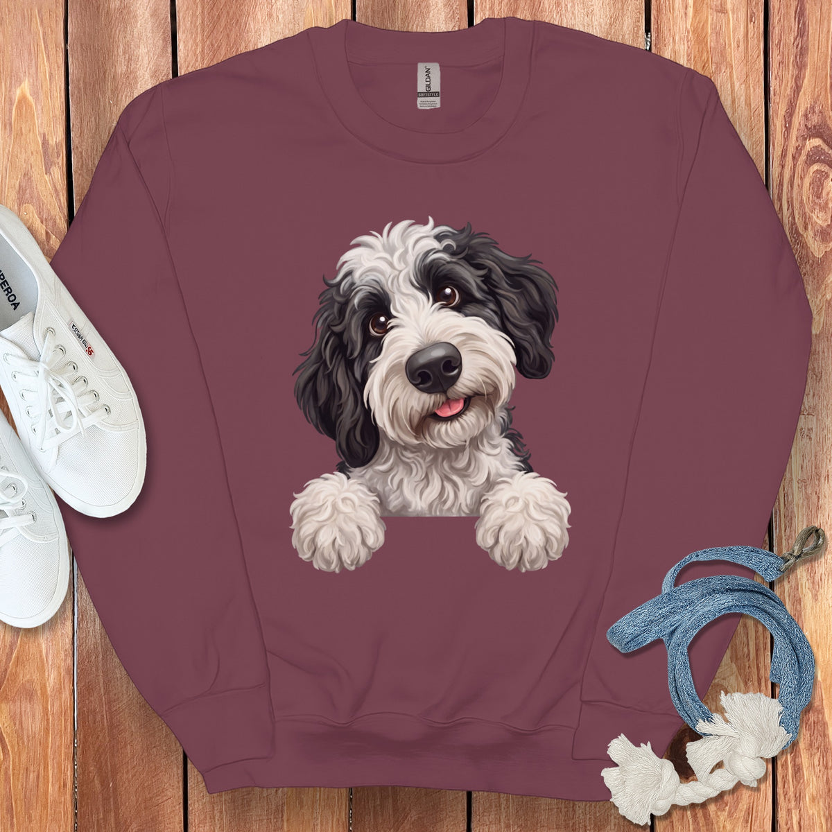 Maroon sweatshirt with black and white fluffy dog illustration and white sneakers.
