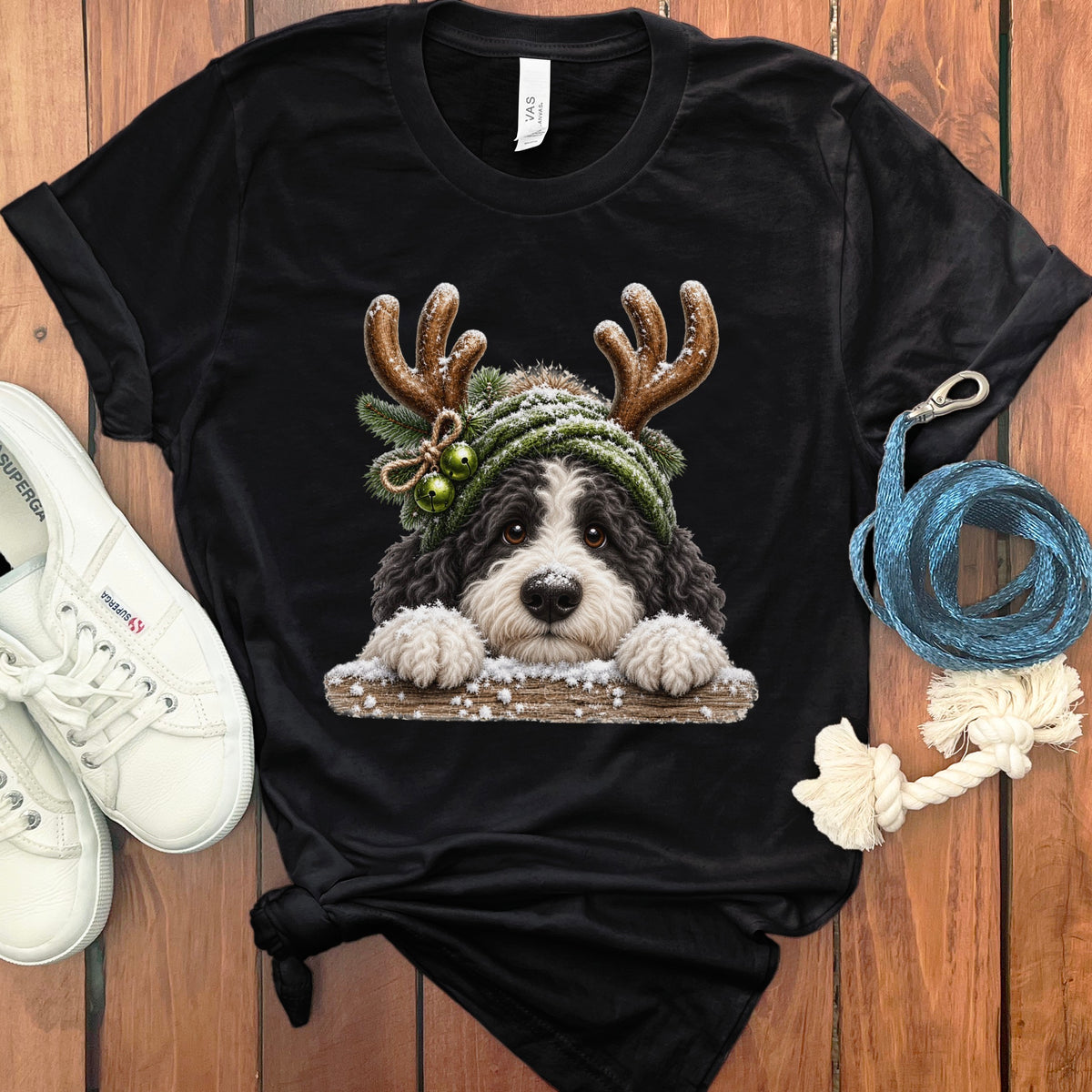 Black t-shirt with a Christmas dog graphic wearing reindeer antlers and a knit hat.