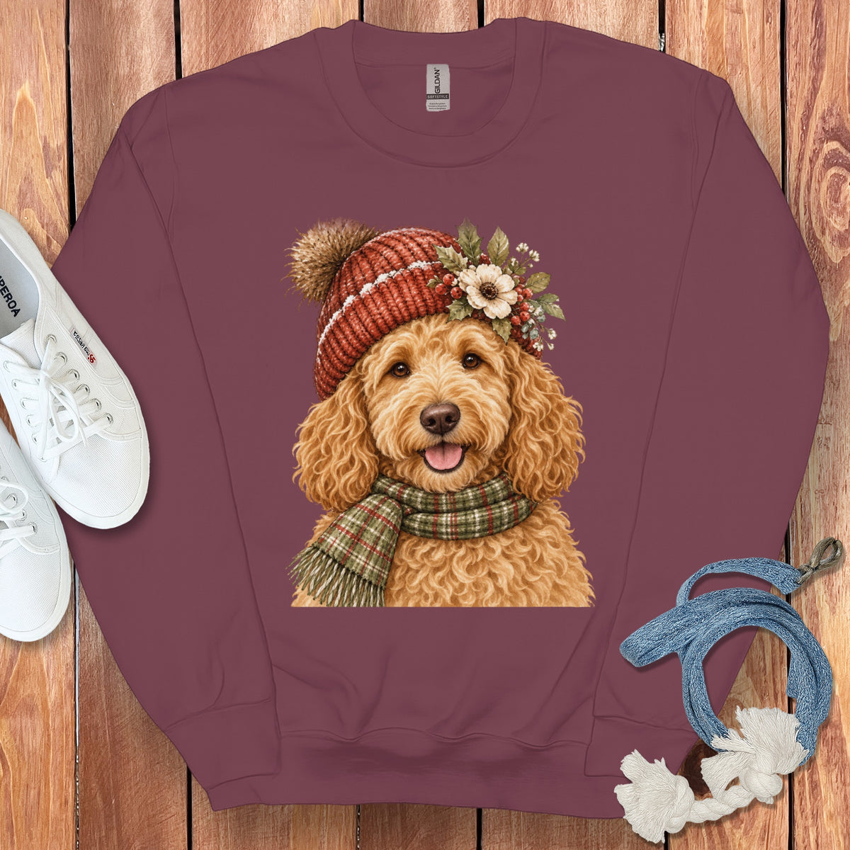 Maroon sweatshirt with goldendoodle wearing a knit hat, scarf, and floral accents.