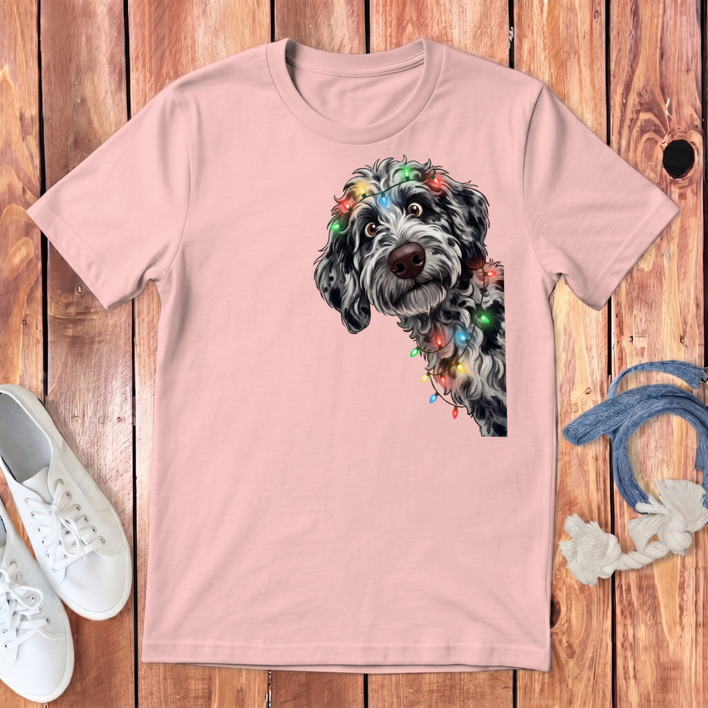 Pink t-shirt with a black and white fluffy dog wearing colorful string lights.