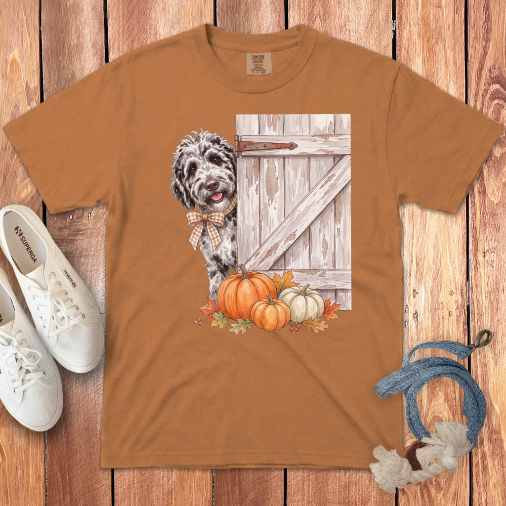 Brown t-shirt with a dog peeking from behind a rustic door with pumpkins.