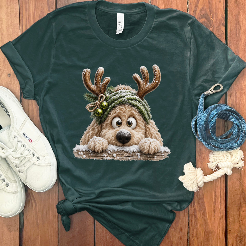 Green t-shirt featuring a fluffy dog with reindeer antlers in the snow.