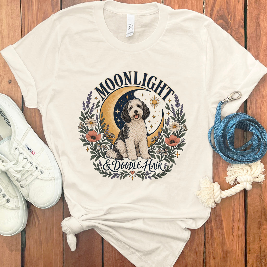 Cream t-shirt with a doodle dog graphic, moon, sun, and text "MOONLIGHT & DOODLE HAIR".