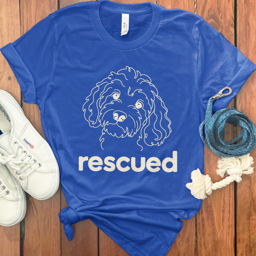 Blue t-shirt with white outline of a dog's face and the word "rescued".