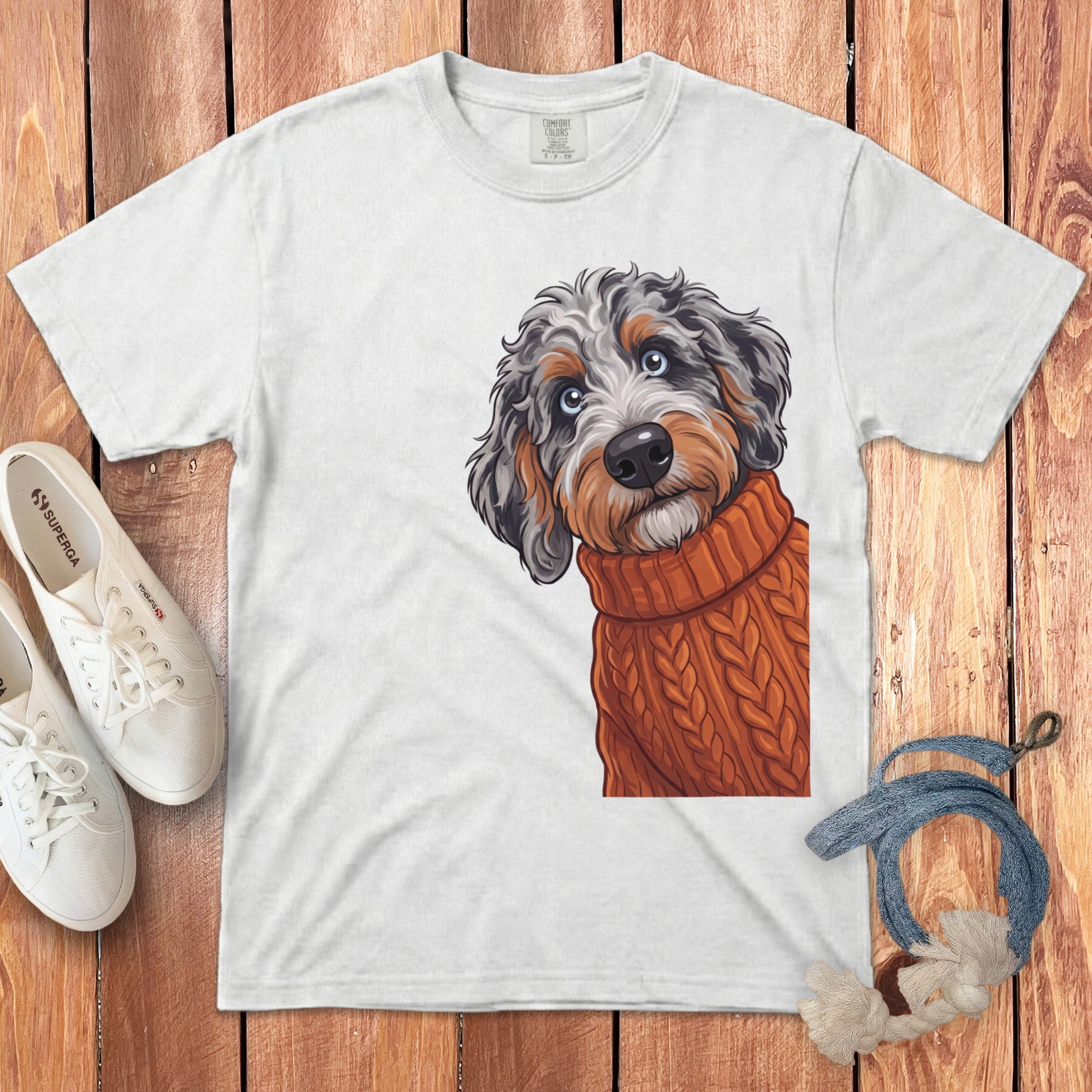 White t-shirt with a doodle of a dog wearing an orange sweater.