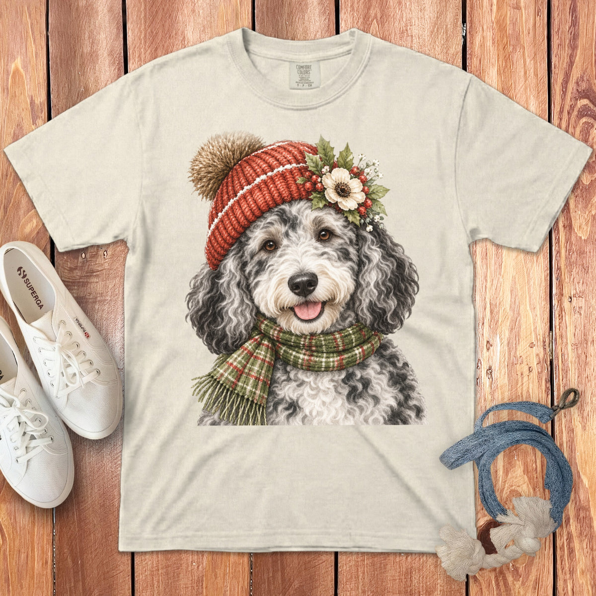 Cream t-shirt with a watercolor print of a doodle dog wearing a Santa hat and scarf.