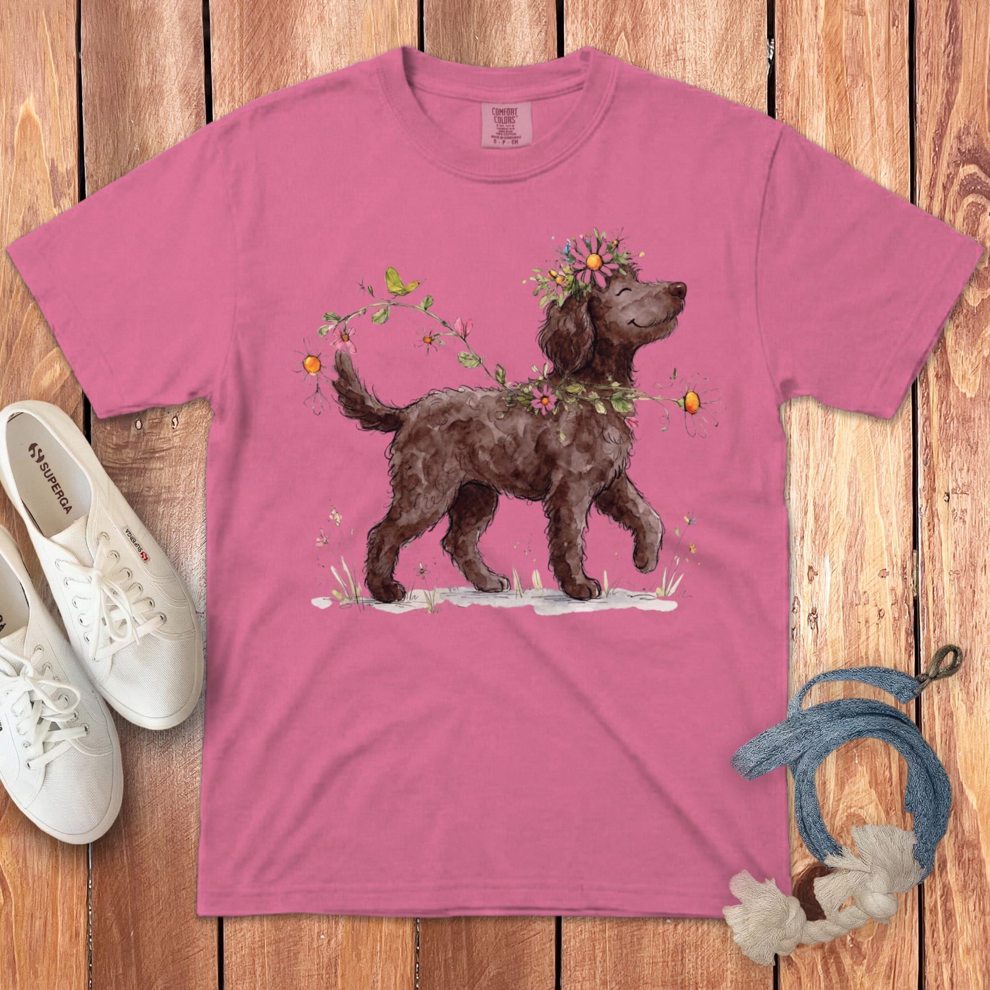Pink t-shirt with a watercolor drawing of a brown dog wearing a flower crown.