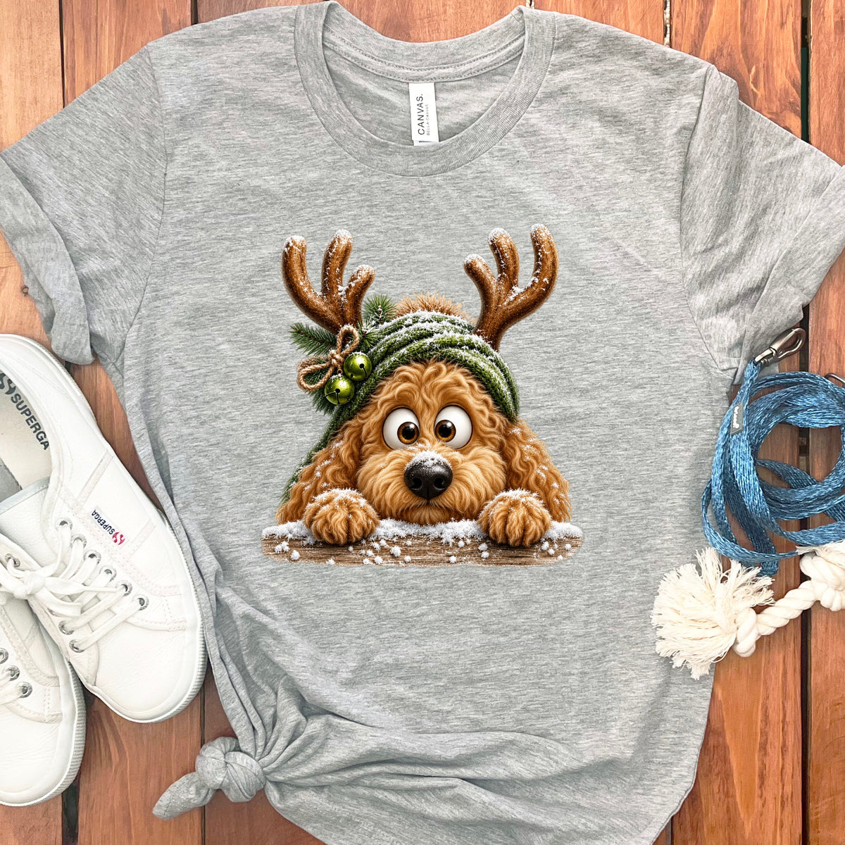 Grey t-shirt with a cartoon doodle dog wearing antlers and a hat.