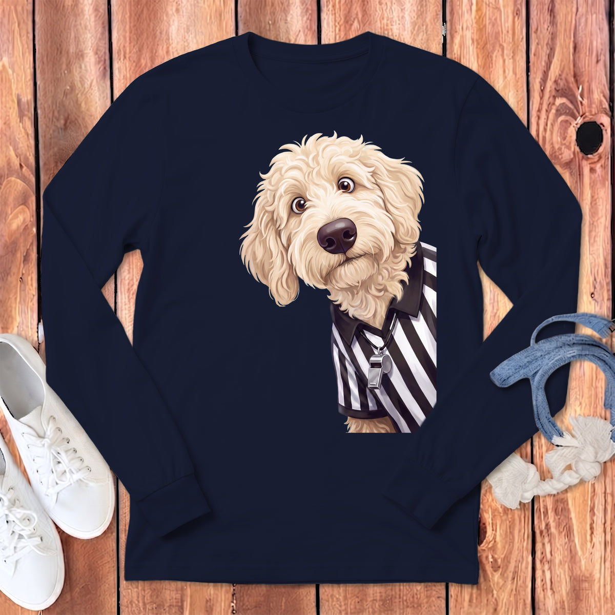 Golden doodle dog wearing a referee shirt with a whistle on a navy long-sleeved shirt.
