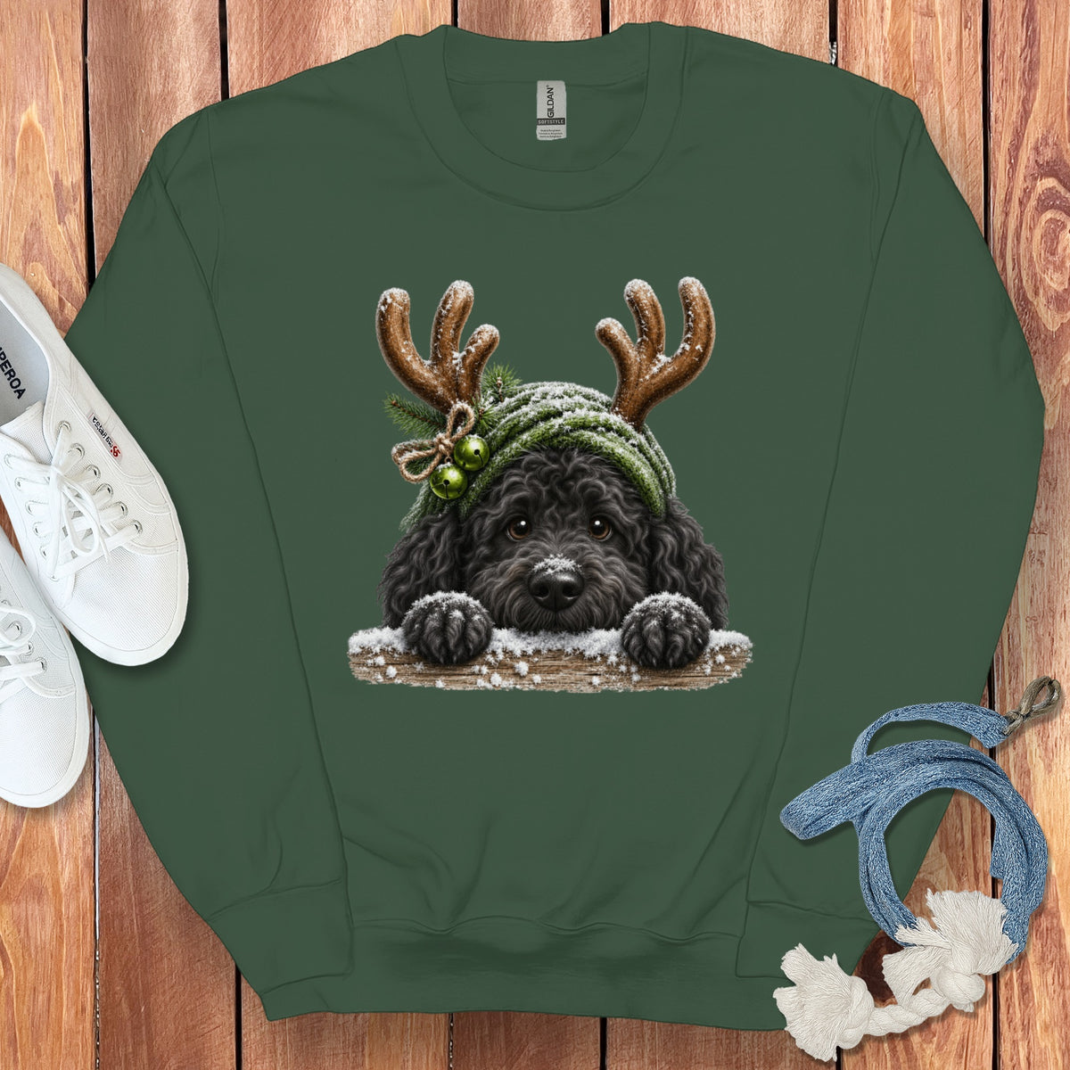 Green sweatshirt with a black doodle dog wearing reindeer antlers and a green hat.