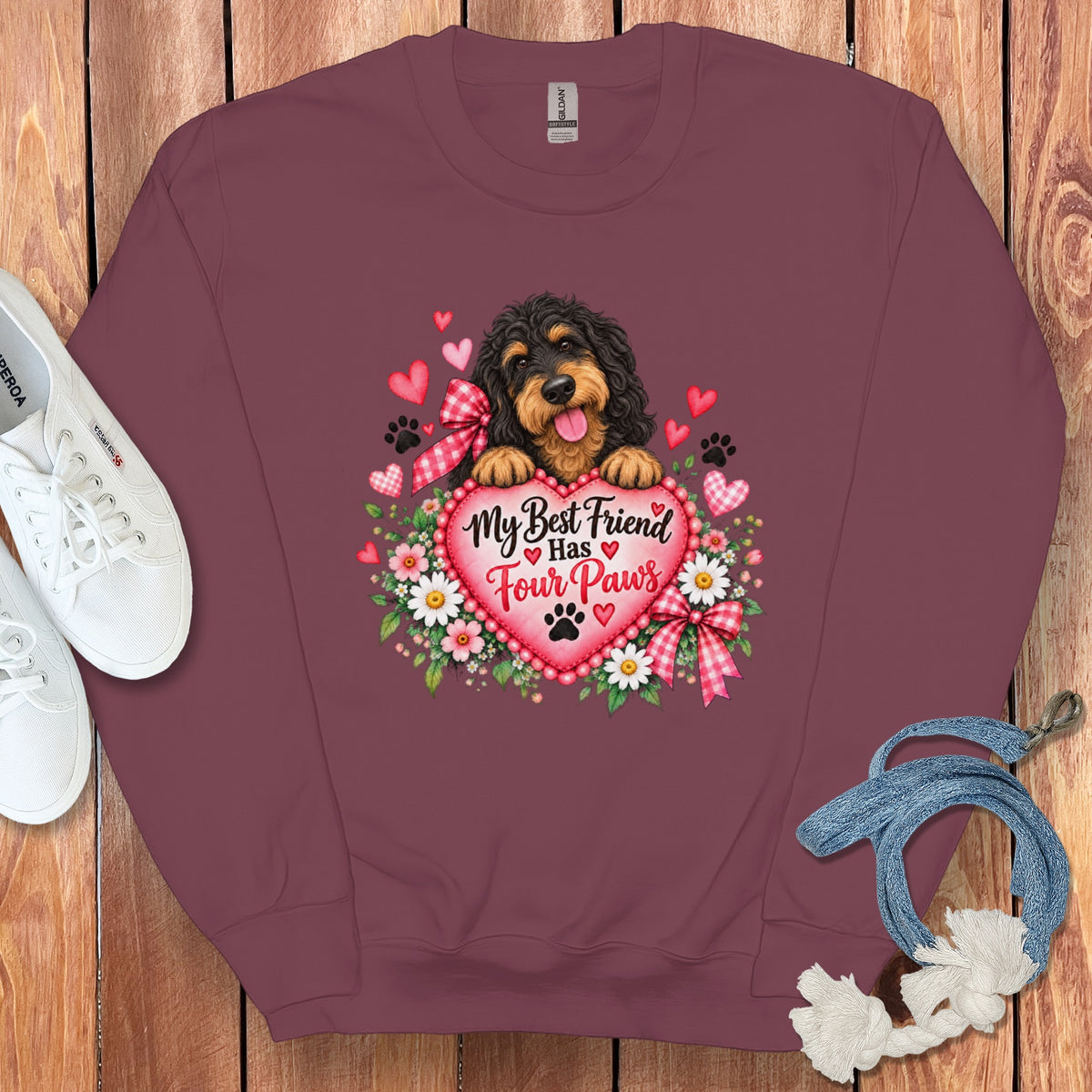 Maroon crewneck sweatshirt featuring a graphic of a dog holding a heart with text that reads My Best Friend Has Four Paws.