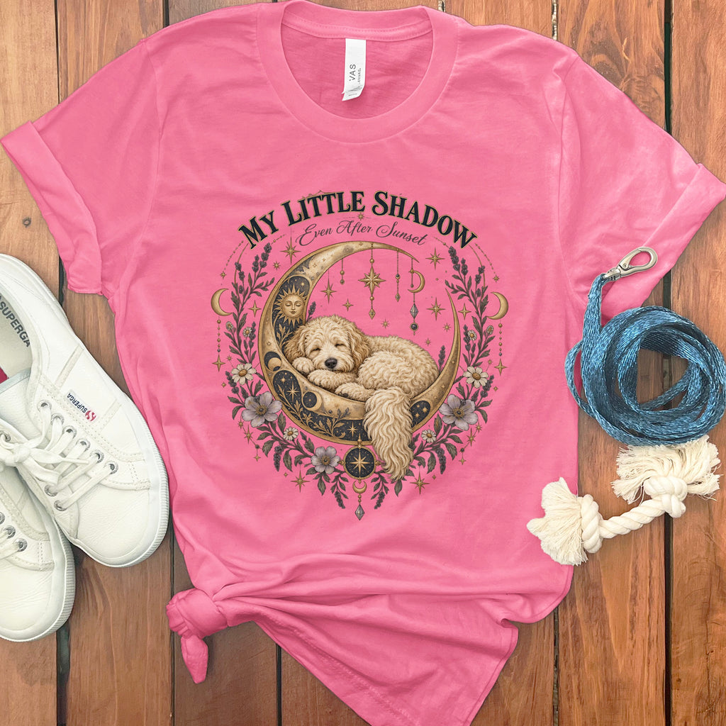 Pink t-shirt with a gold and black crescent moon design featuring a sleeping dog, stars, and flowers. Text reads "MY LITTLE SHADOW Even After Sunset".