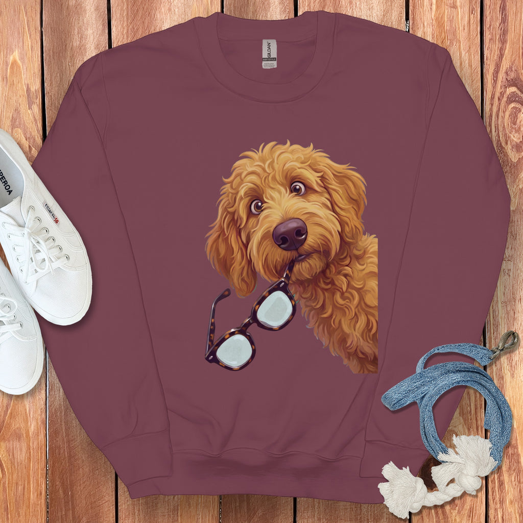 Maroon crewneck sweatshirt featuring a graphic of a golden fluffy dog holding glasses in its mouth.