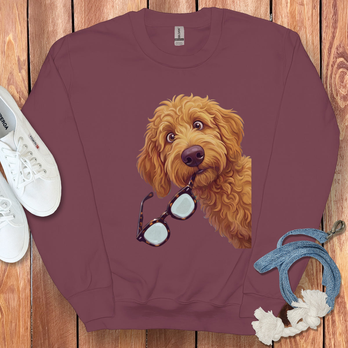 Maroon crewneck sweatshirt featuring a graphic of a golden fluffy dog holding glasses in its mouth.
