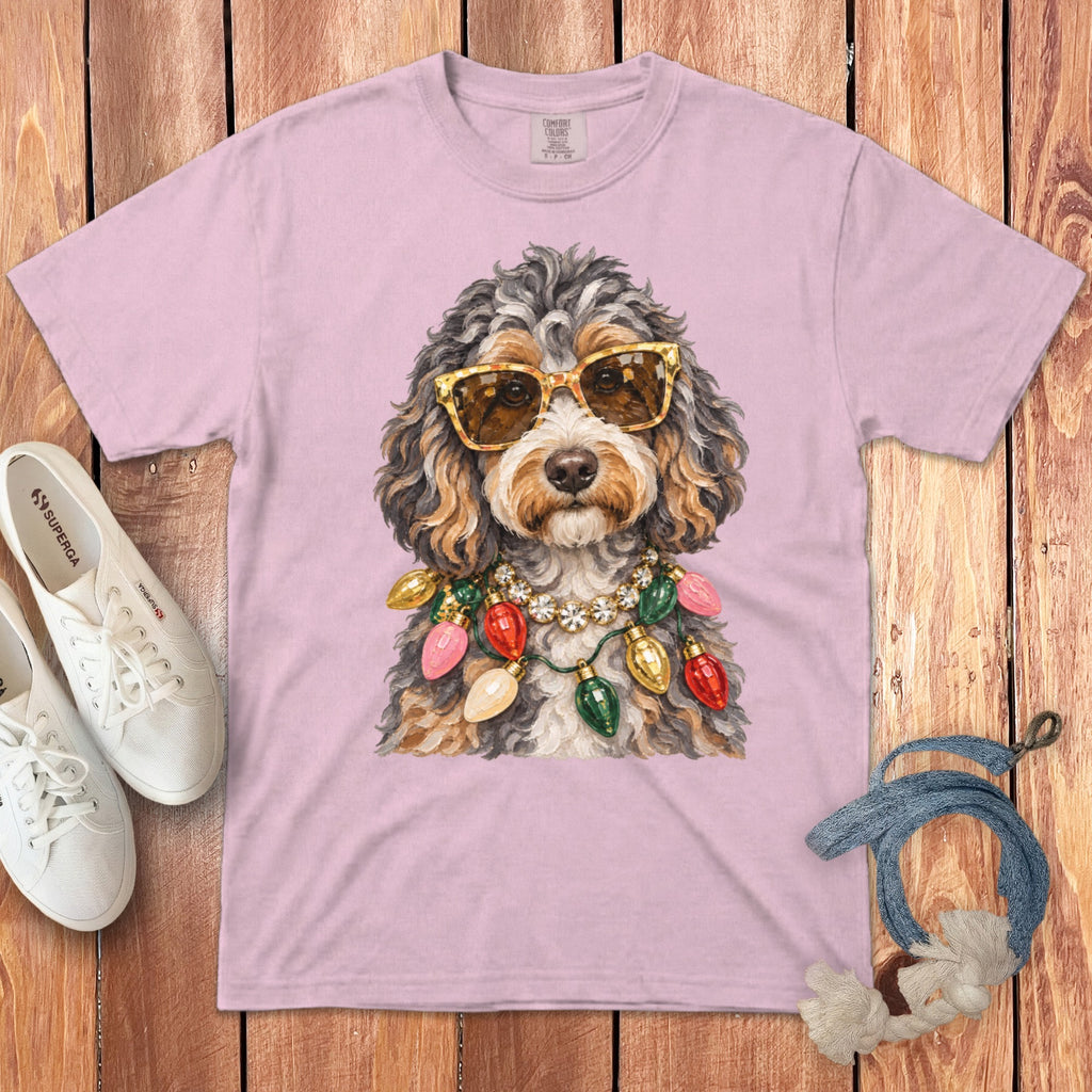 Pink t-shirt featuring a doodle wearing sunglasses and a festive light string necklace.