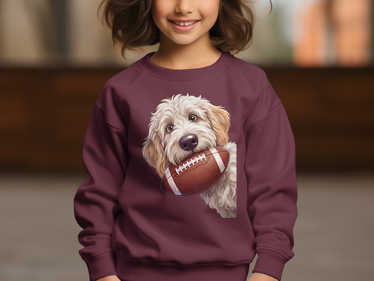 Sweatshirt with cream-colored dog holding a football on maroon fabric