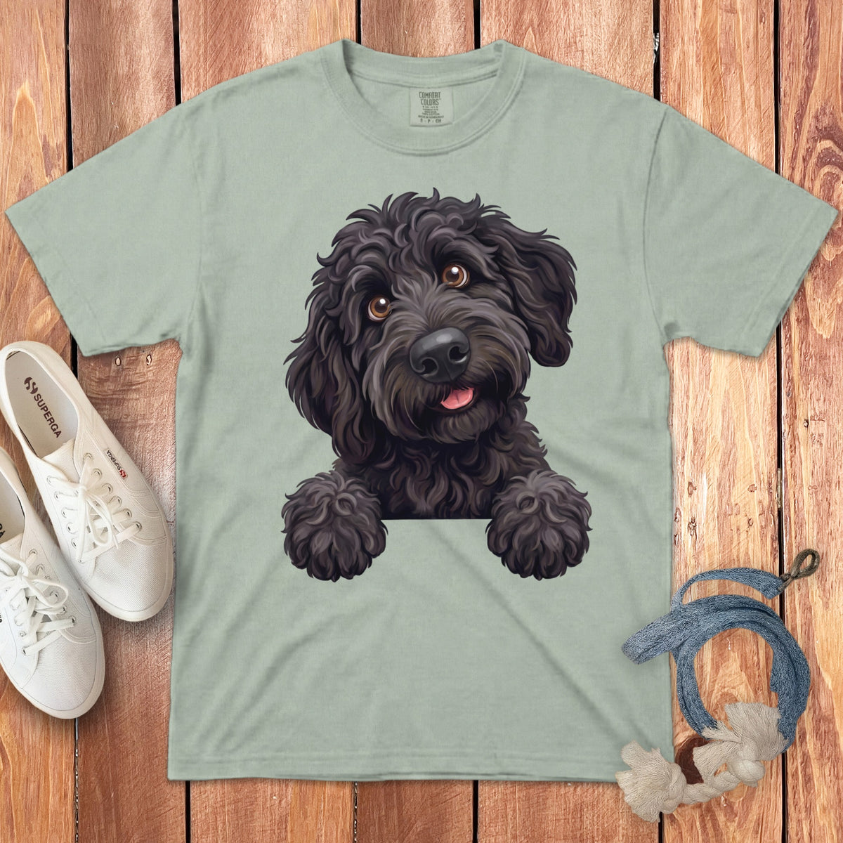 Light green t-shirt with a cartoon black poodle peeking over the collar.