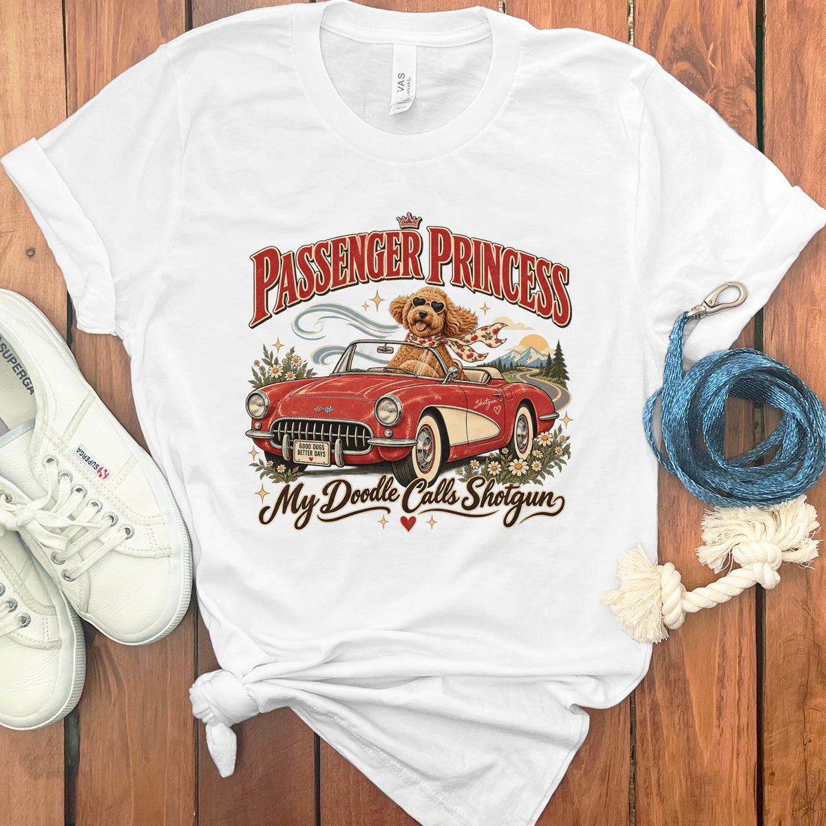 White t-shirt with graphic of a dog in a red convertible, text "Passenger Princess" and "My Doodle Calls Shotgun".