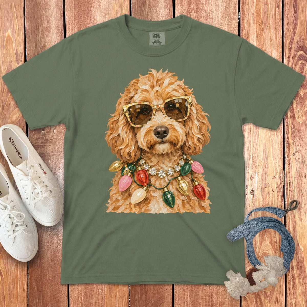 Green t-shirt with a painting of a dog wearing sunglasses and holiday lights.