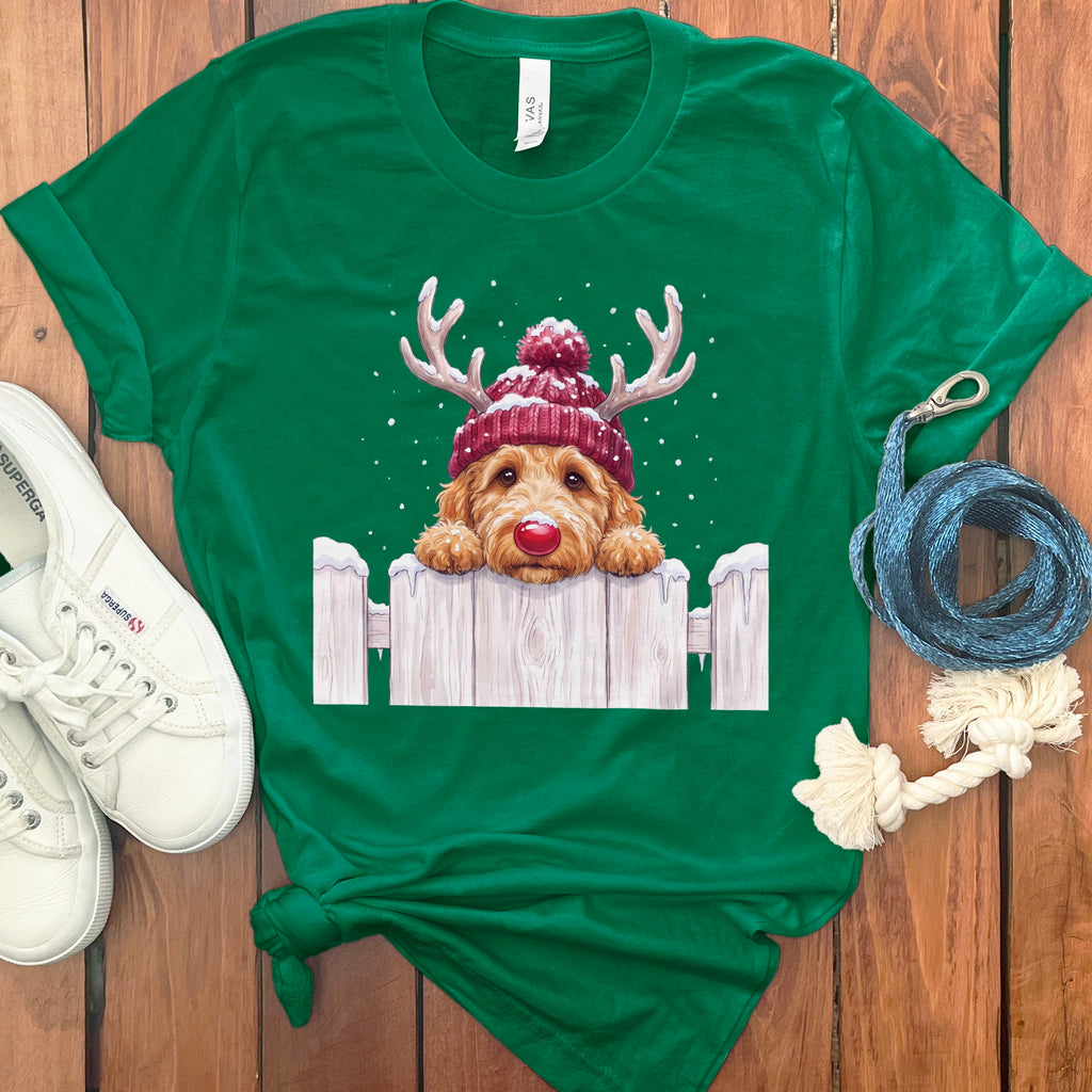 Green t-shirt with a doodle dog wearing a Santa hat and antlers peeking over a fence.