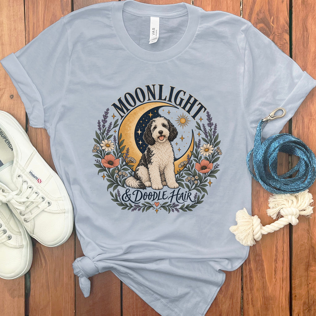 Light blue t-shirt with doodle dog graphic, crescent moon, and text "MOONLIGHT & DOODLE HAIR".