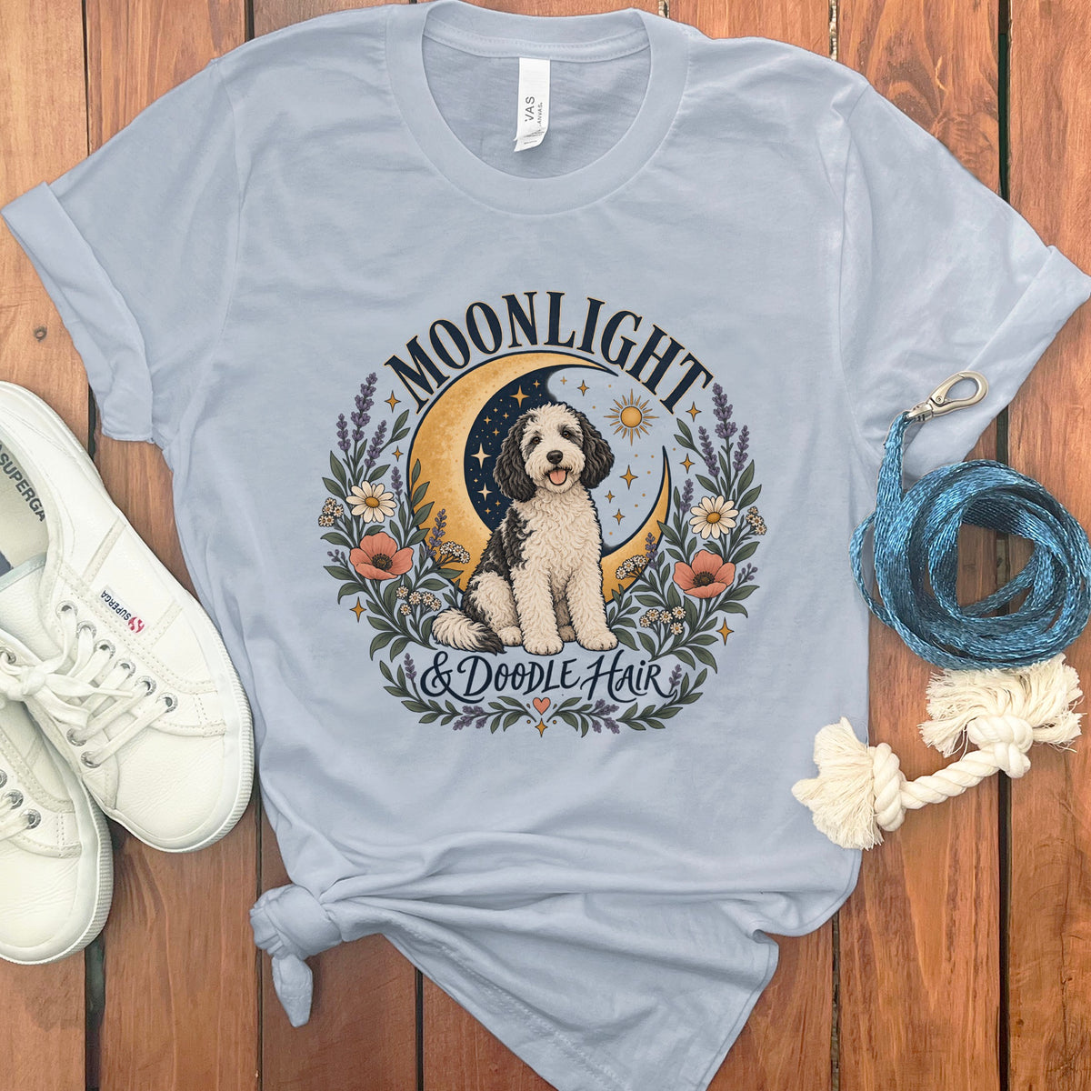 Light blue t-shirt with doodle dog graphic, crescent moon, and text "MOONLIGHT & DOODLE HAIR".