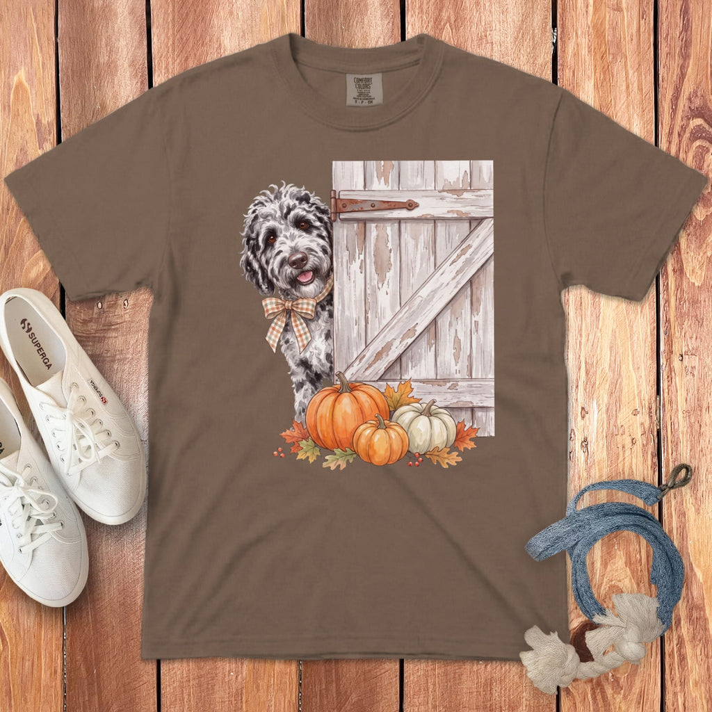 Brown t-shirt with a doodle dog, rustic door, pumpkins, and fall leaves graphic.