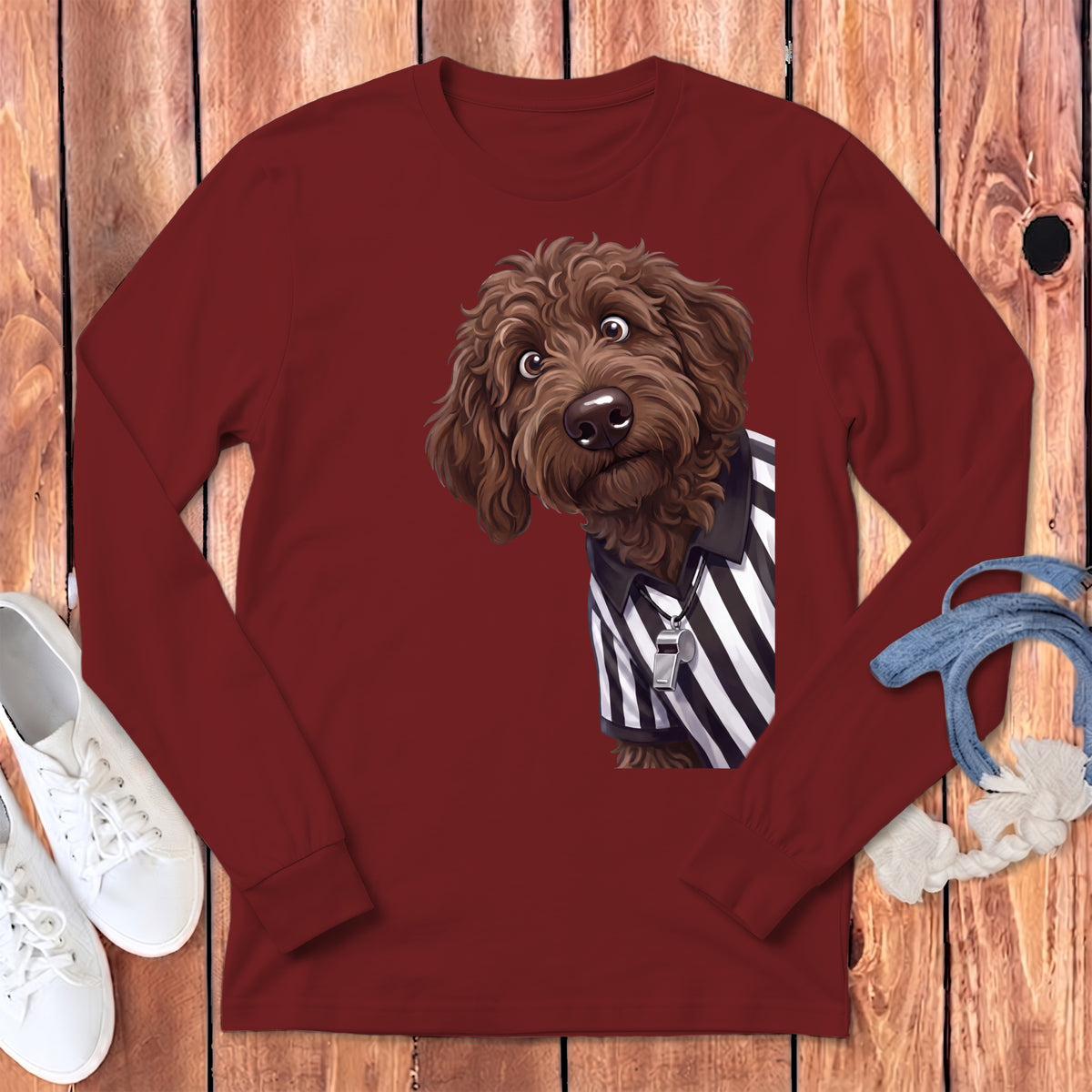Brown dog in referee shirt with whistle on maroon long sleeve shirt.