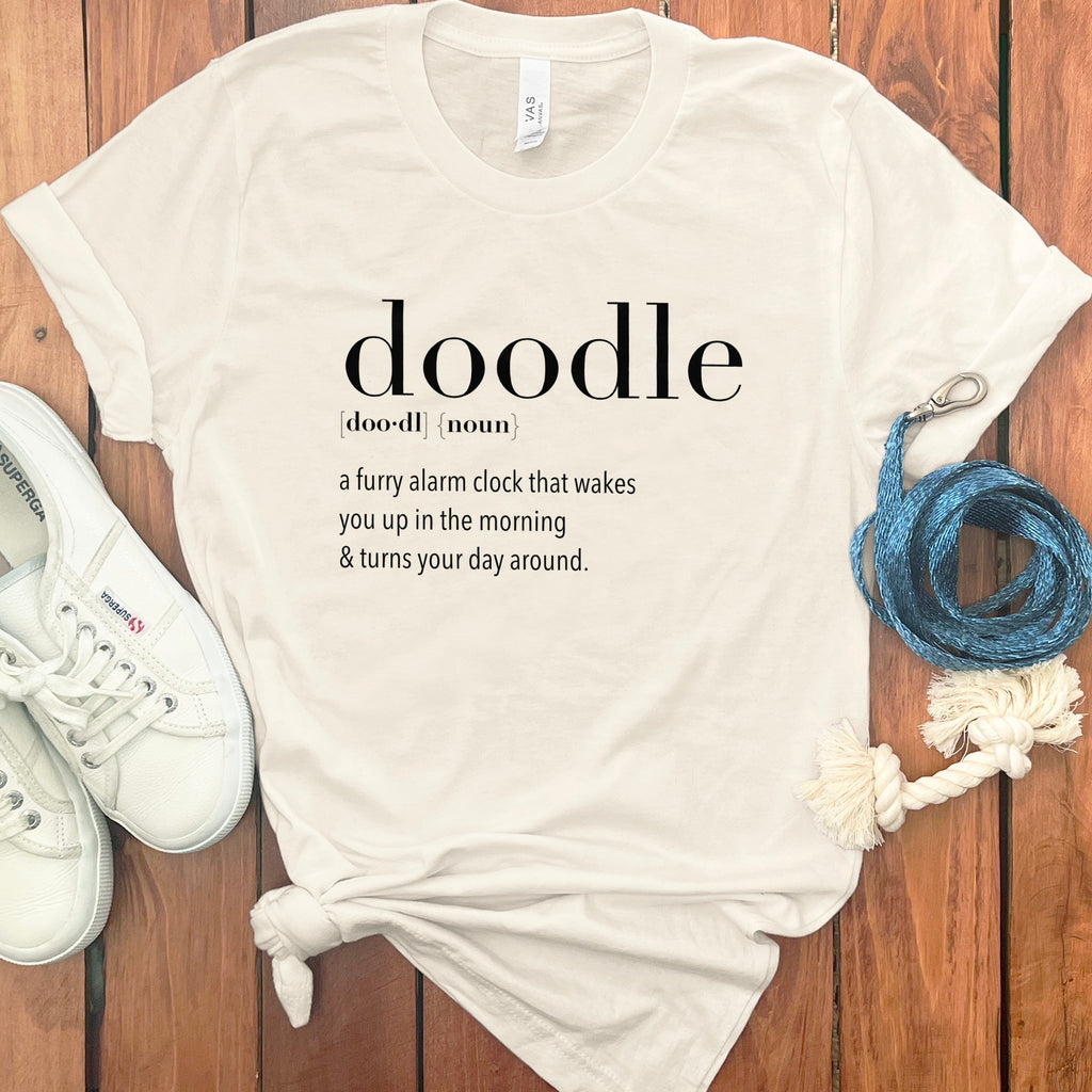 Cream t-shirt with black text defining "doodle" as a furry alarm clock.