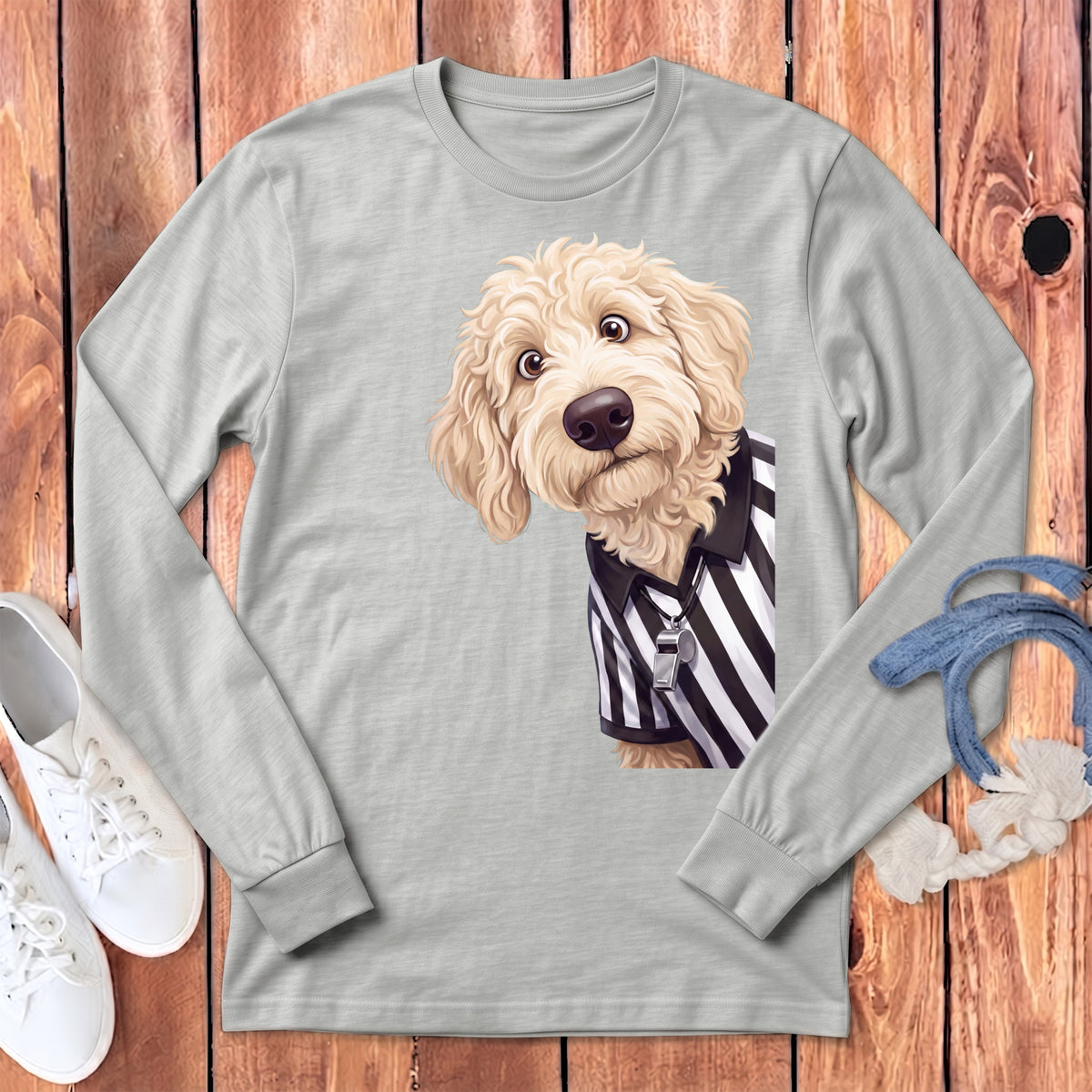 Goldendoodle dog wearing a referee shirt and whistle on a light gray long-sleeve shirt.