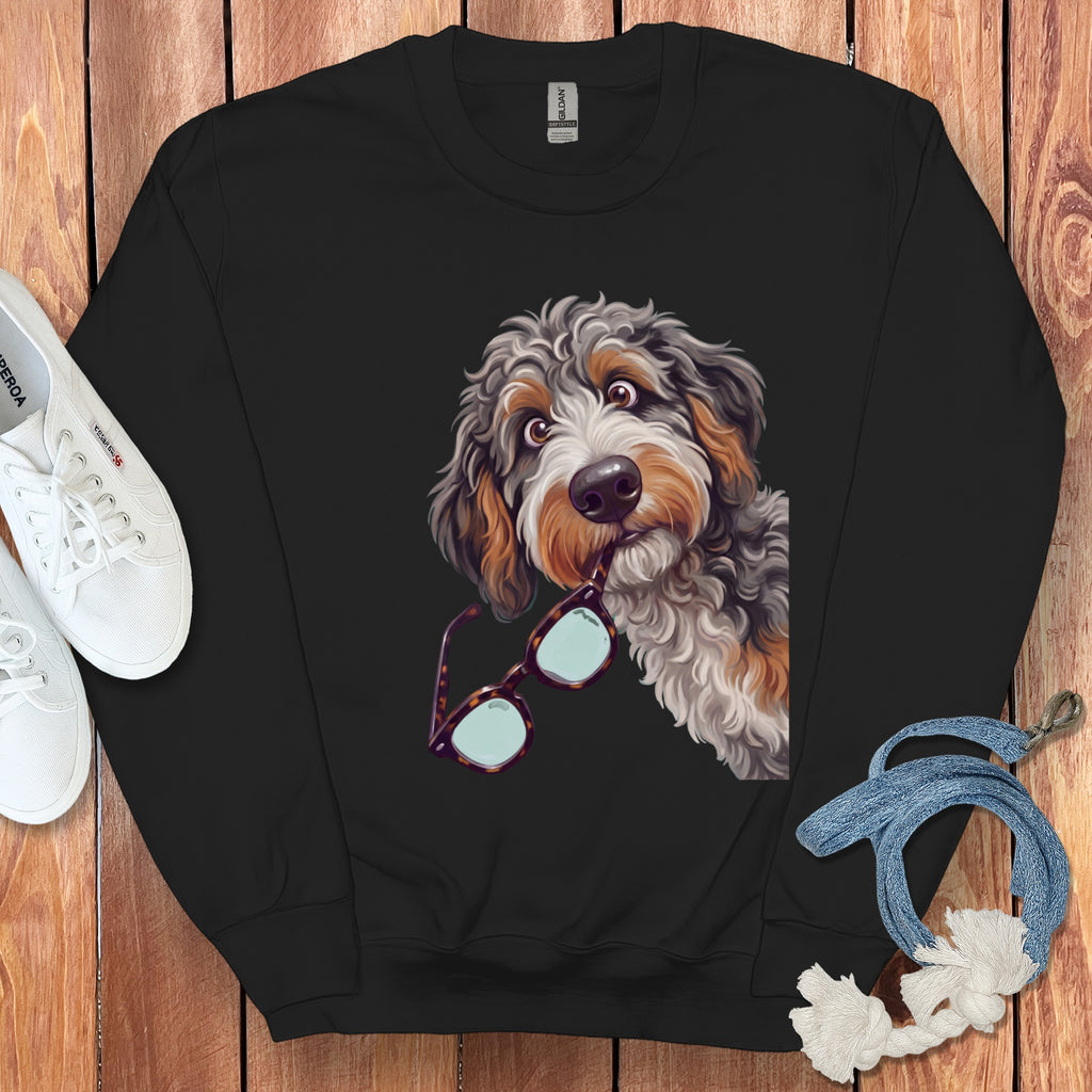A black crewneck sweatshirt features an illustrated doodle dog holding glasses in its mouth.