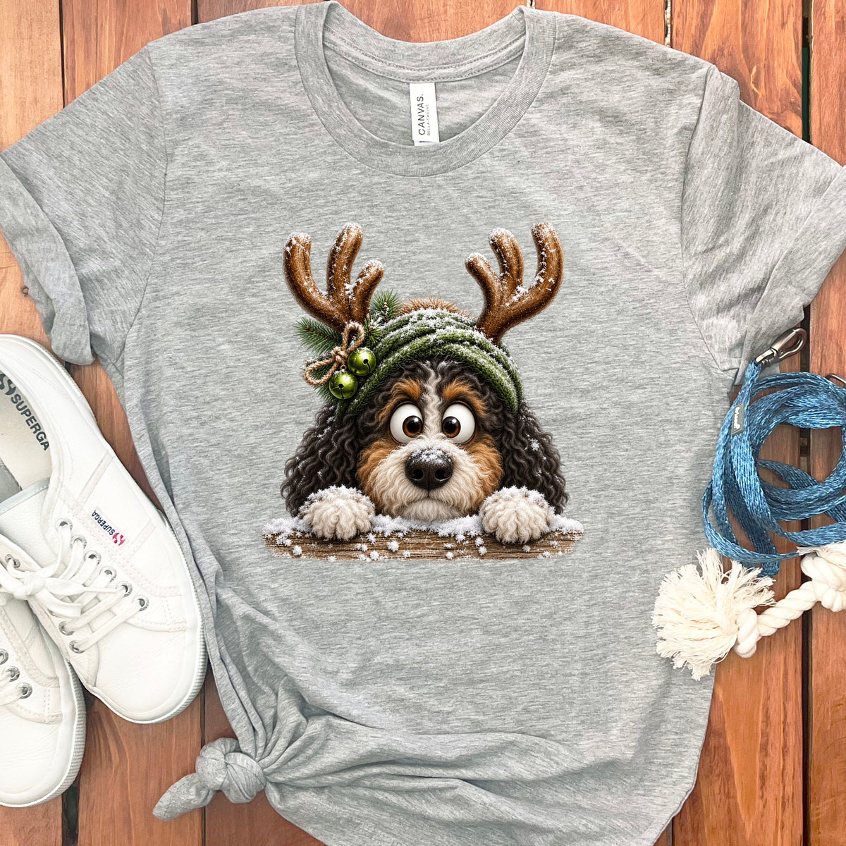 Grey t-shirt with a cute dog wearing reindeer antlers and a knit hat.