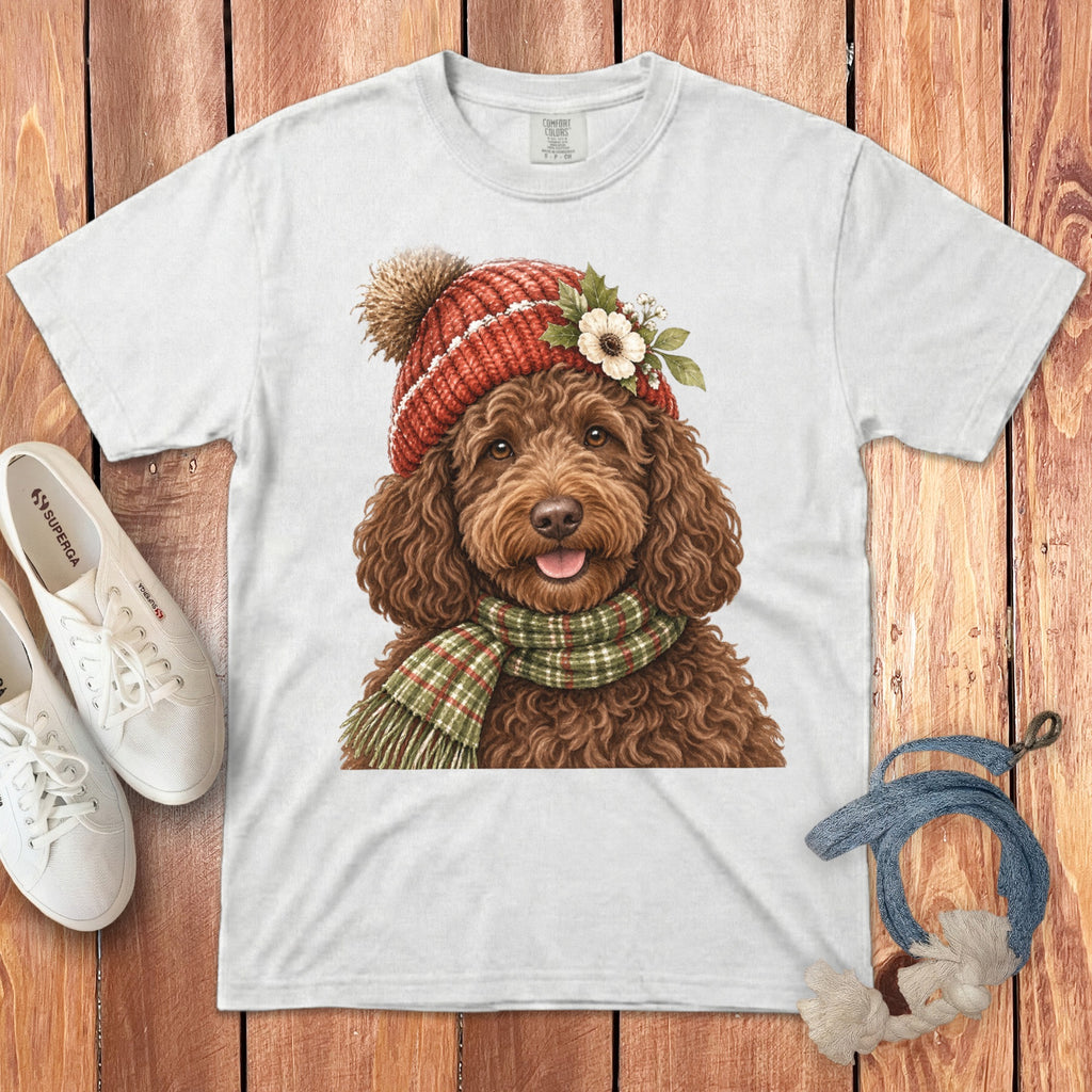 White t-shirt with watercolor illustration of a brown doodle dog wearing a red knit hat and scarf.