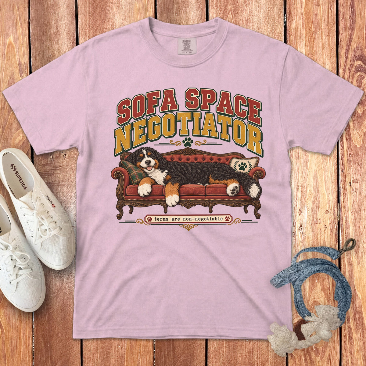 Light pink t-shirt featuring a graphic of a Bernese Mountain Dog on a red sofa with text reading Sofa Space Negotiator.