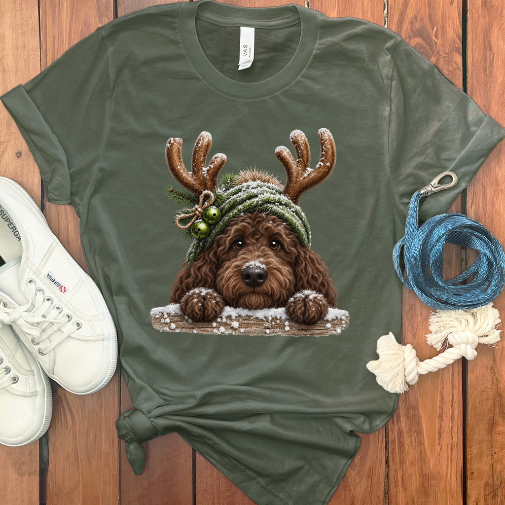 Brown doodle dog wearing antlers and a green hat with bells on a t-shirt.
