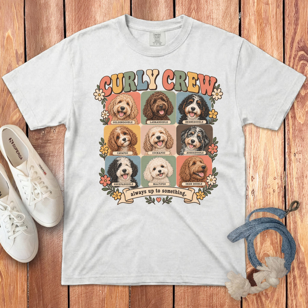 White t-shirt featuring a retro graphic of nine doodle dog breeds labeled Curly Crew always up to something.