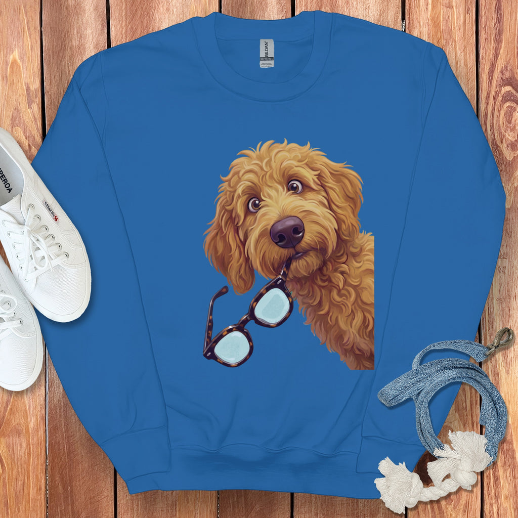 Bright blue crewneck sweatshirt featuring a graphic of a golden fluffy dog holding glasses in its mouth.