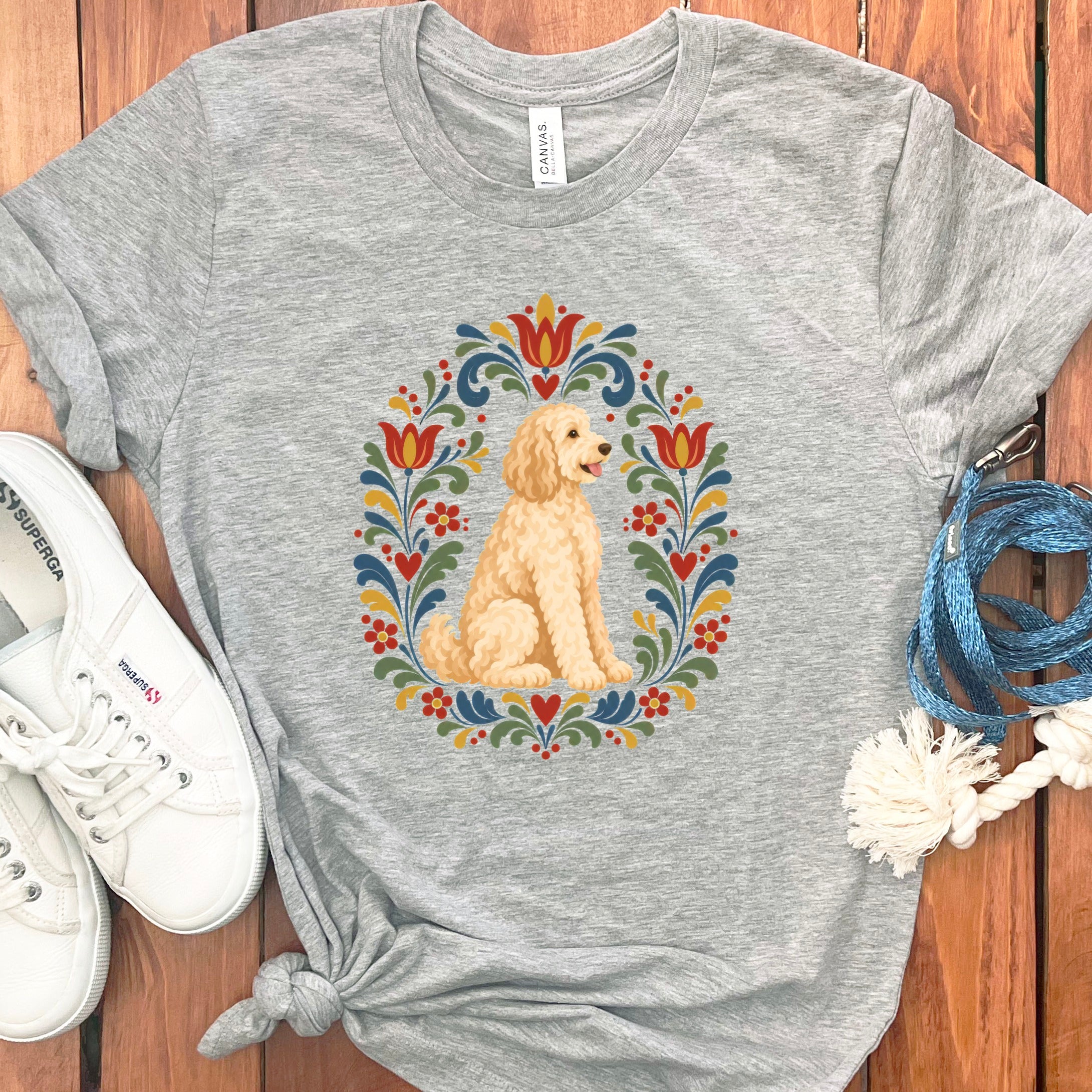 Grey t-shirt with a golden doodle in a colorful folk art floral wreath.