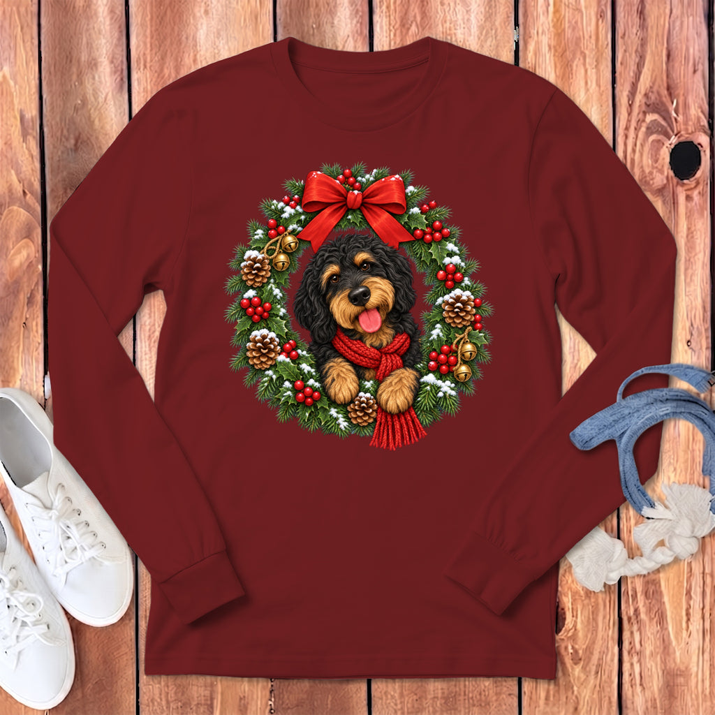 Maroon long-sleeved crewneck sweatshirt featuring a graphic of a black and brown dog inside a snowy Christmas wreath.