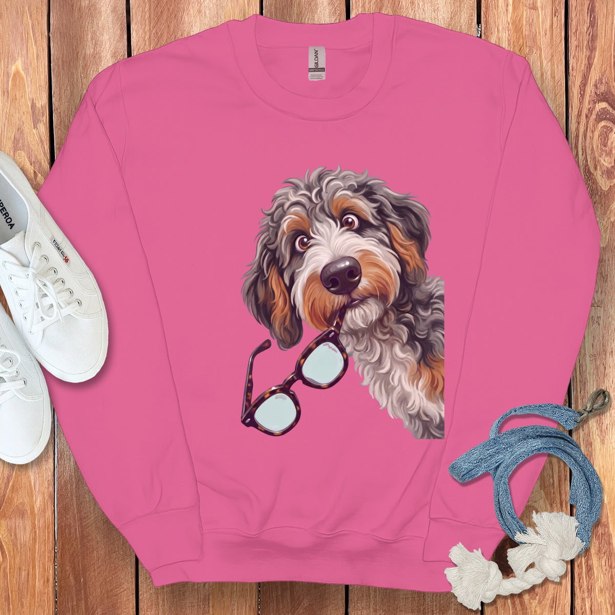 Pink crewneck sweatshirt featuring a graphic of a shaggy dog holding glasses in its mouth.