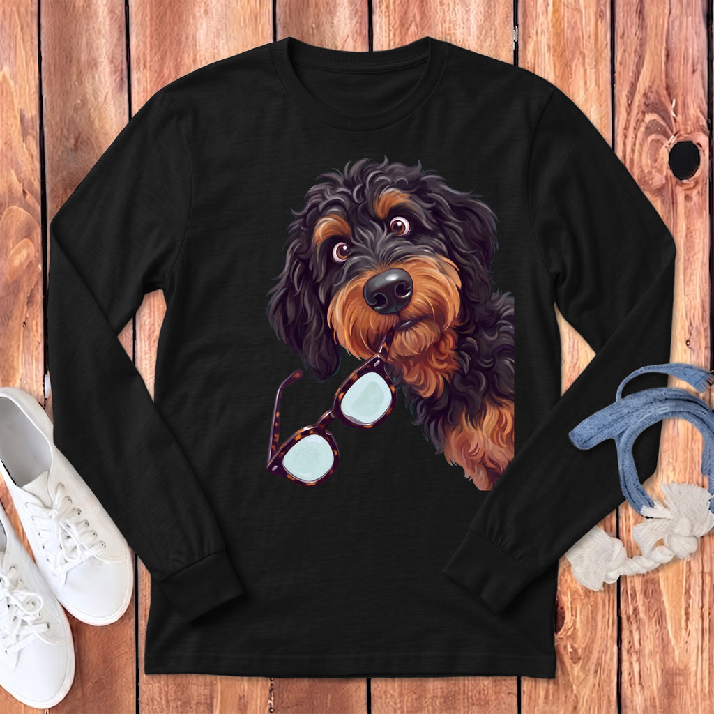 Black long-sleeve t-shirt featuring a cartoon illustration of a black and tan doodle dog holding glasses in its mouth.