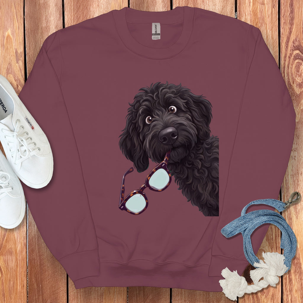 Maroon crewneck sweatshirt featuring a graphic of a black doodle dog holding glasses in its mouth.